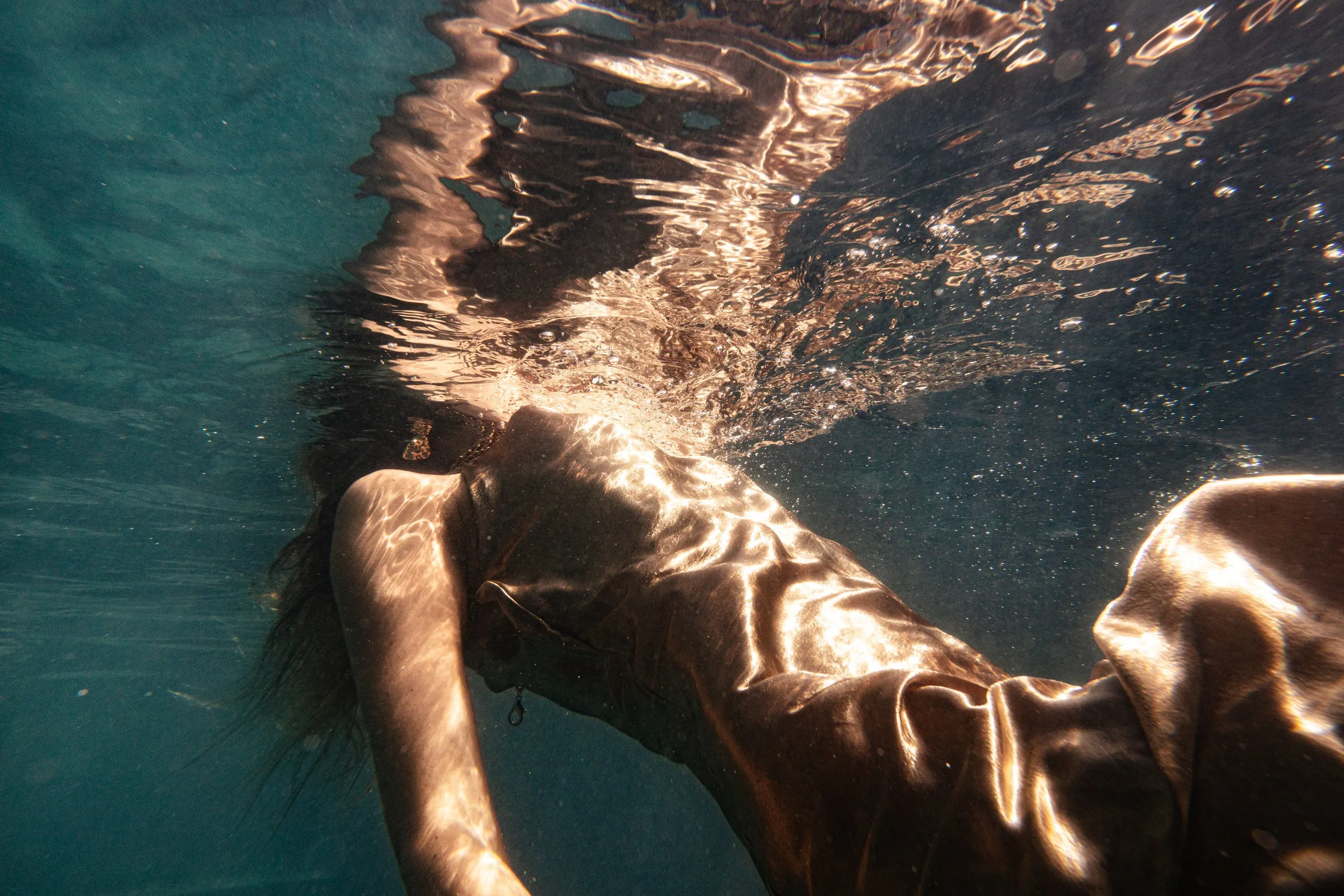 Underwater portrait bathed in golden light