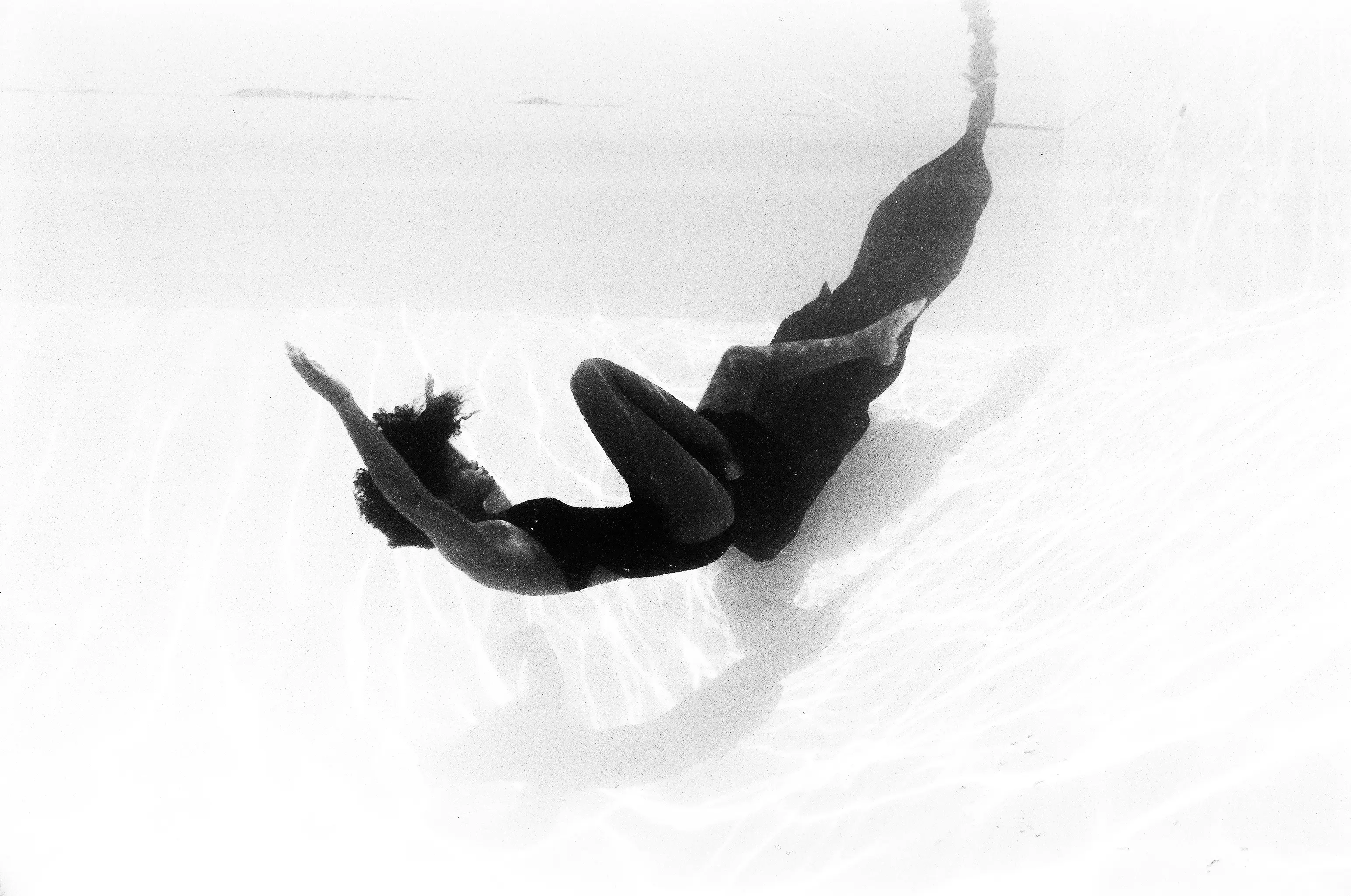 Black-and-white figure drifting downward through open water