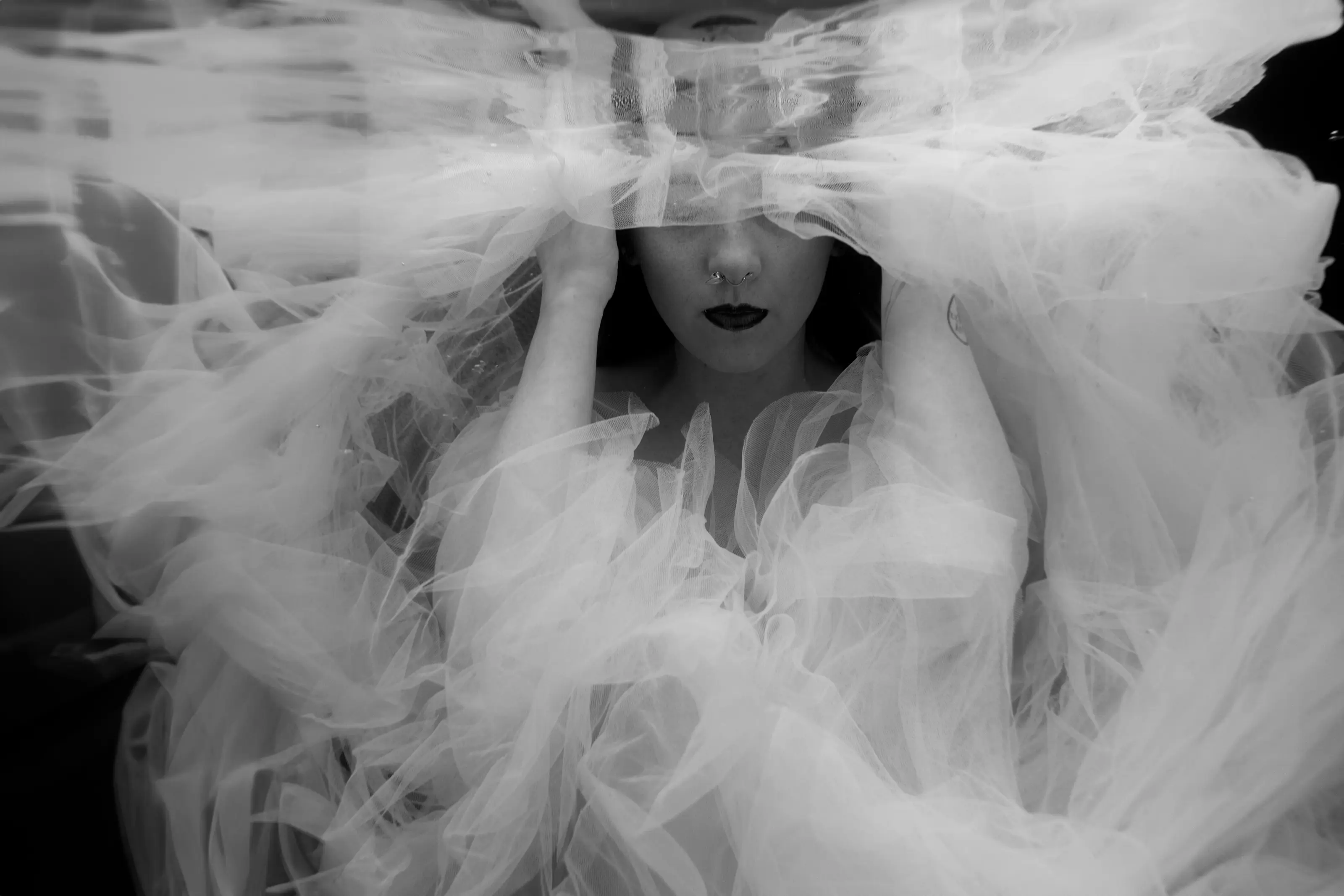 Black-and-white face seen through a veil of water and fabric